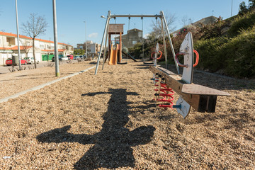 A seesaw and other swings in an empty park in a peripheral area of Caceres, Extremadura, Spain.