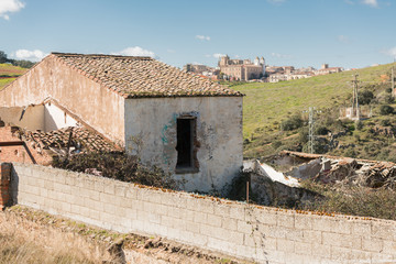 An abandoned house with the old town of Caceres in the background. Extremadura, Spain. 