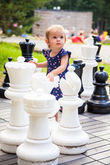 little baby girl playing giant chess