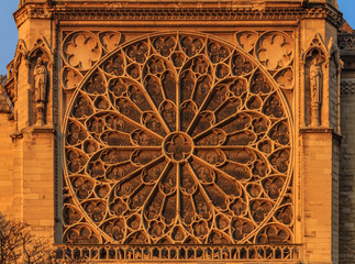 Details of the southern facade of Notre Dame de Paris Cathedral facade with the rose window and ornate tracery in the warm light of sunset