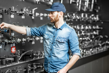 Man choosing sanitary taps in the shop