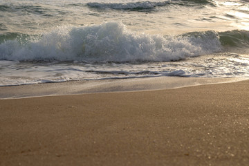 Scenic view of the waves of the blue sea on the sandy shore.
Wild nature. Storm. Sunset on the sea.