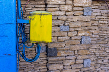 Antique yellow phone cable connection box on a blue phone post. Copy space background with comunications topic.