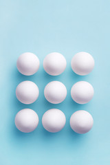White eggs pattern on a blue background viewed from above. Top view. Copy space