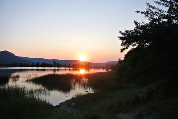 Naklejka na ściany i meble Beautiful sunset on the lake in summer with mountain views