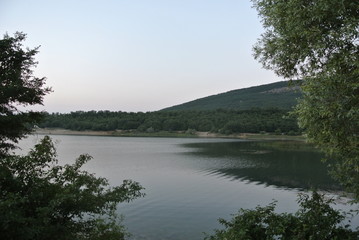 Fototapeta na wymiar Beautiful sunset on the lake in summer with mountain views