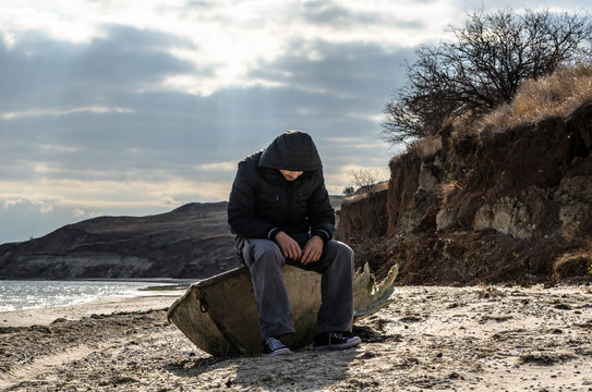 man is sitting aboard a broken boat
