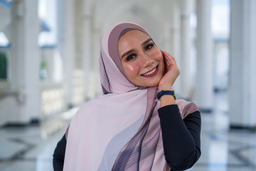 Attractive young stylish woman wearing shawl or hijab, smile and posing.