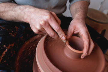 Professional potter making bowl in pottery workshop, studio