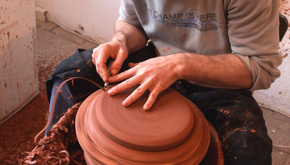 hands of potter creating a jar