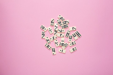 Board game dominoes on a pink background