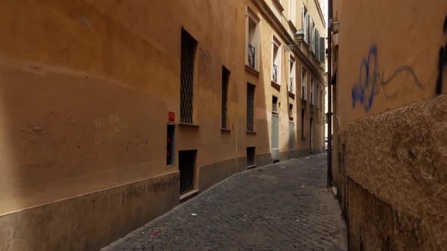 First person view of someone walking along deserted alley in Rome, Italy. POV of tourist going through narrow street