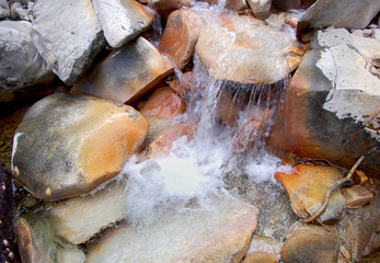 Clear creek water cascades over colorful river stones make abstract pattern in South mineral creek river stones along the Rico Silverton trail in the San Juan range of the Colorado Rockies.