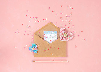 Paper hearts in scrapbooking technique and pink and red sweets sugar candy hearts fly out of craft...