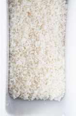 Top view of coconut chips in a white tray