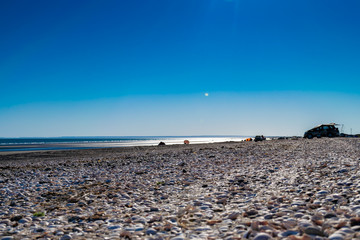  small beach rocks with blue sky and against beach light