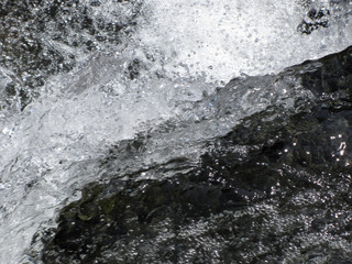 Water flowing and splashing over rocks background