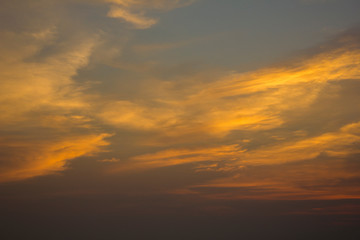 Naklejka na ściany i meble yellow golden clouds in the evening dark blue sunset sky