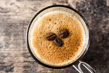 coffee glass and coffee grain on wooden table. Top view