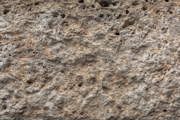 Textured uneven stone surface. Yellow limestone. Background image. Construction material.