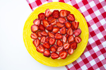 Bright and delicious strawberry cake on a red napkin in a cage