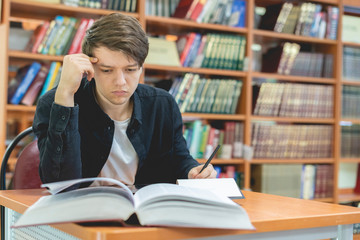 student take notes in his notebook at school or university b