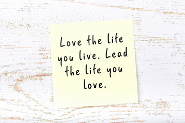 Positive inspiring quote handwritten on sticky note on wooden background