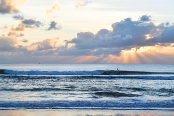 The sun sets over the sea, a beautiful sunset with clouds and waves in the sea.