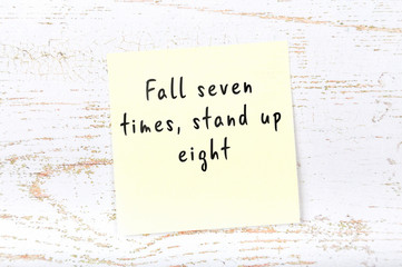 Positive inspiring quote handwritten on sticky note on wooden background