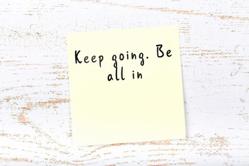 Positive inspiring quote handwritten on sticky note on wooden background