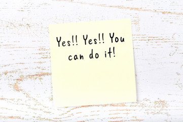 Positive inspiring quote handwritten on sticky note on wooden background