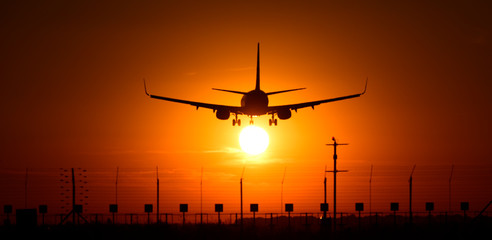 Fototapeta na wymiar Silhouette of airplane in the sunset 