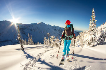 Girl makes ski mountaineering alone toward the mountain pass in a nice track with sealskin