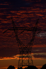high voltage poles and sunset