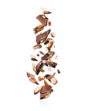 Pieces of chocolate bar with almonds falling down on white background