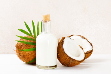 Coconut milk in the glass bottle on the white table