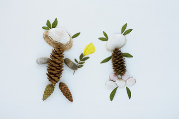 figures of lovers from natural materials from the forest and the sea coast: stones, leaves, shells, cones, dried flowers