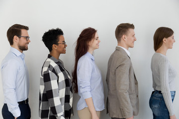 Side view at happy diverse business people standing in queue