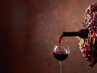 Red wine pouring from a bottle into a glass.