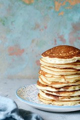 A stack of lush punkcakes for breakfast on a gray background. High pile of delicious pancakes with berries.American Cuisine, Copy space