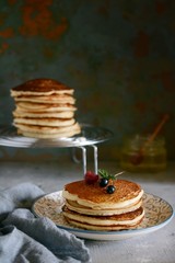 A stack of lush punkcakes for breakfast on a gray background. High pile of delicious pancakes with berries.American Cuisine, Copy space