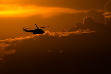 Fototapeta na wymiar Helicopter silhouette a t sunset time during Bucharest BIAS air show 