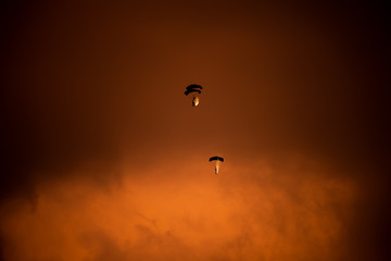 Obraz na płótnie Canvas Parachute silhouette a t sunset time during Bucharest BIAS air show 