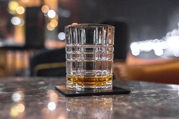 Male strong alcoholic drink. A glass of whiskey, brandy, bourbon, rum or tequila. Digest in the restaurant. Drink amber color. Scotch or Irish whiskey. Bar background. Elite alcohol.