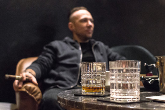 Male strong alcoholic drink. A glass of whiskey, brandy, bourbon, rum or tequila. Digest in the restaurant. Drink amber color. Scotch or Irish whiskey. Bar background. Elite alcohol. - Powered by Adobe