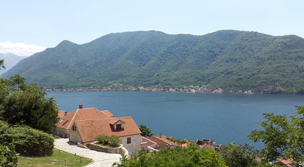 orange roofs of Perast town and green mountains - bay of Kotor in Montenegro