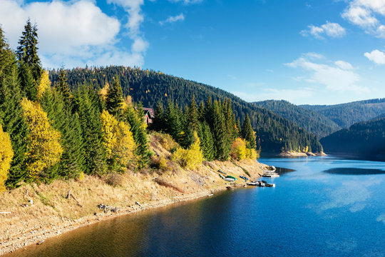 mountain lake reservoir in autumn. hills with coniferous trees in the distance. beautiful nature scenery. sunny weather