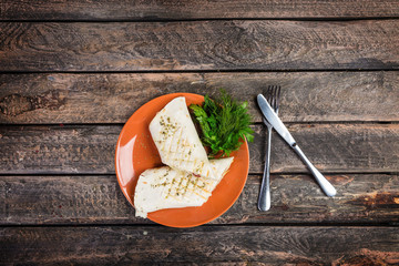 Tortilla wrap with chicken breast and vegetables on a ceramic plate. Served with cutlery on a wooden background.