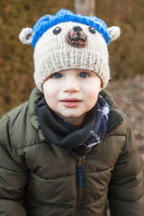 Portrait of child wearing scarf and bear hood, winter