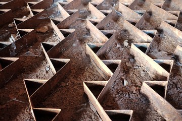 Old rusty parts of rice peeling machine on the dirty ground floor in the paddy mill area